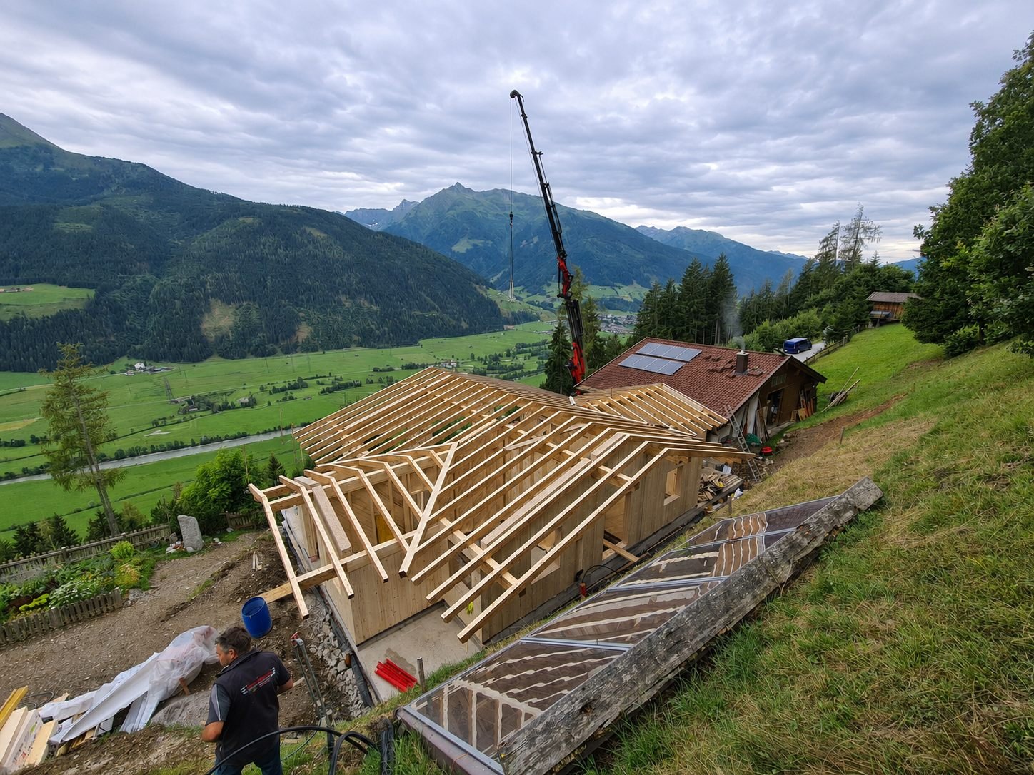 Dachstuhl im Aufbau mit Kran, Blick ins Tal