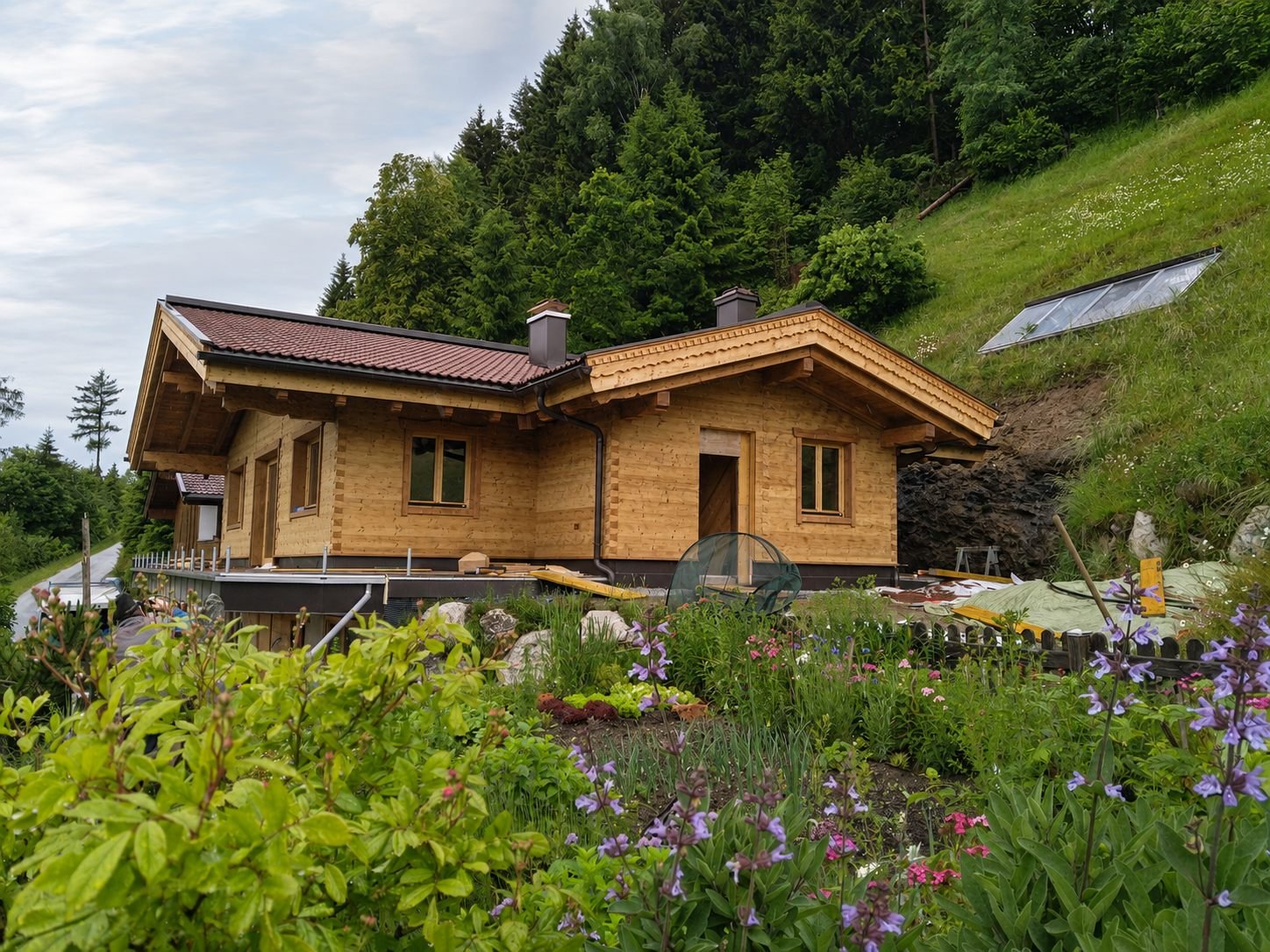 Fertiggestelltes Blockhaus mit blühendem Garten