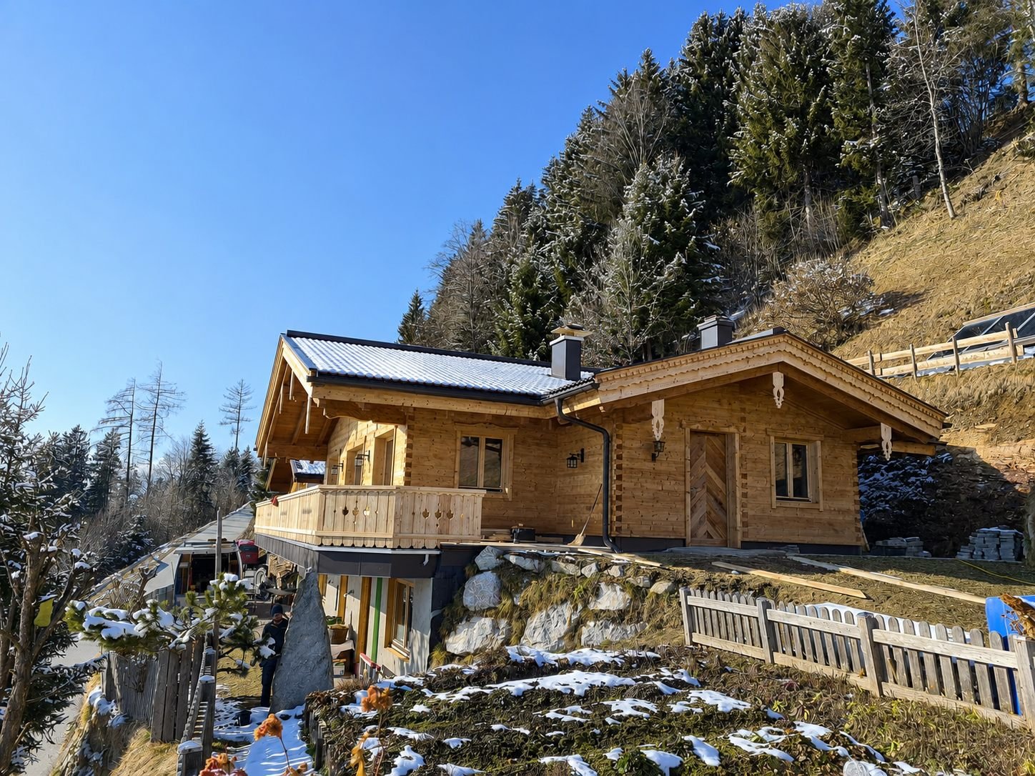 Fertiggestelltes Chalet im Winter mit geschnitzten Dachträgern